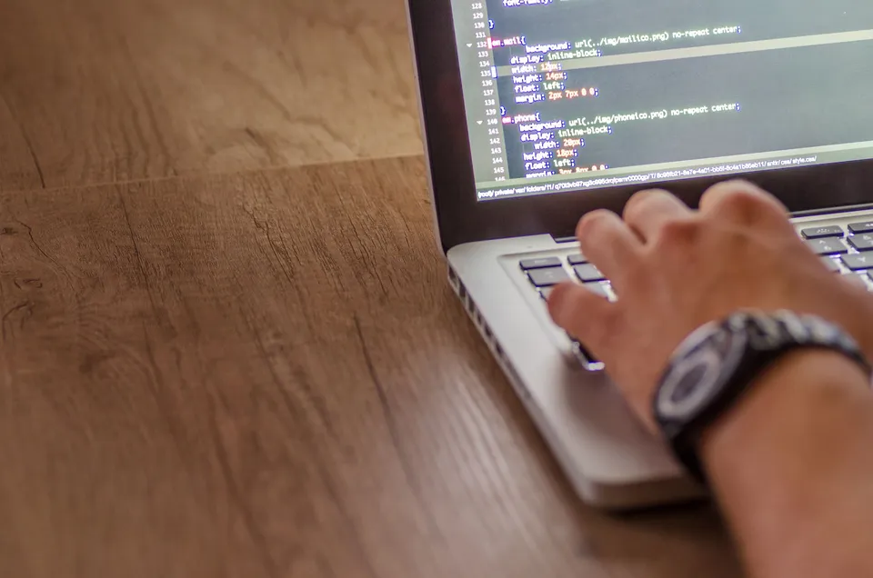 A developer editing website migration code on a laptop