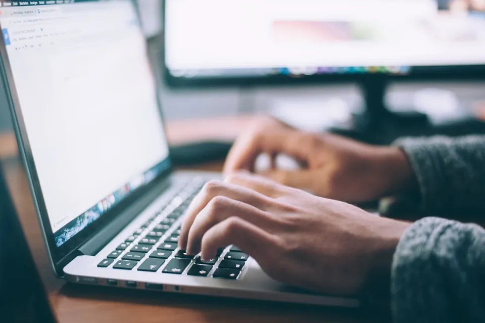 A consultant writing up a documented action plan on a laptop after a client call