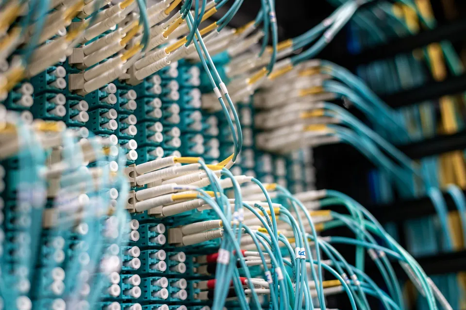 Fiber optic cables plugged into a server rack patch panel during a migration