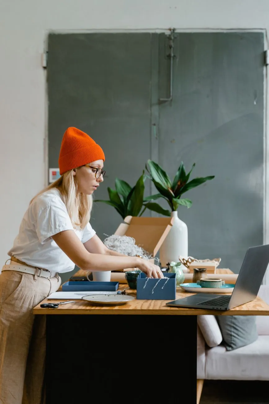 A small business owner working on a laptop at a desk, weighing which platform fits the site