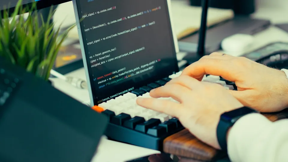 A software engineer writing framework code in a terminal on a laptop
