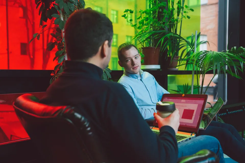 Two colleagues discussing platform options together at a laptop screen