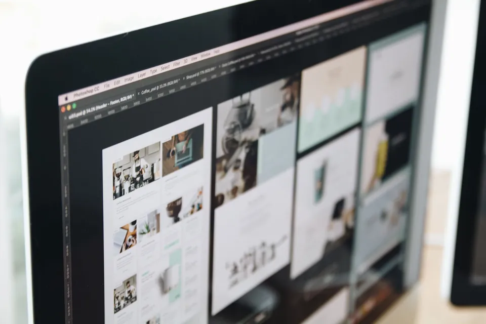 Website page design mockups open on a monitor in a design tool