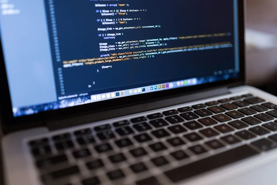 A developer editing WordPress PHP code on a laptop